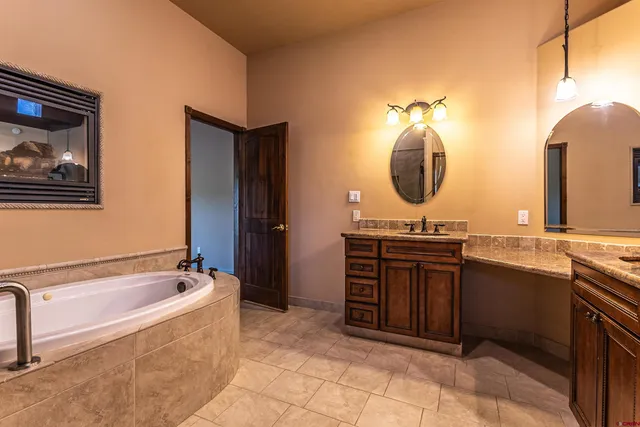 a spacious bathroom with a granite countertop sink and a bathtub