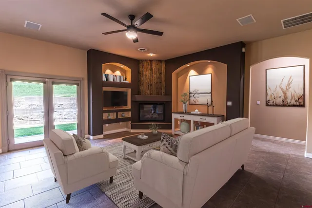a living room with fireplace furniture and a large window