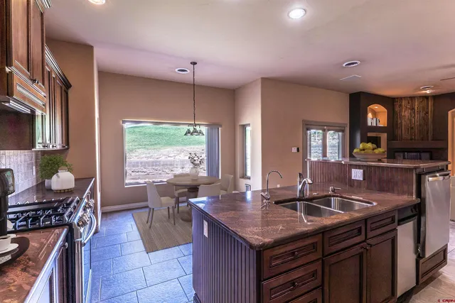 a kitchen with granite countertop a sink and a stove