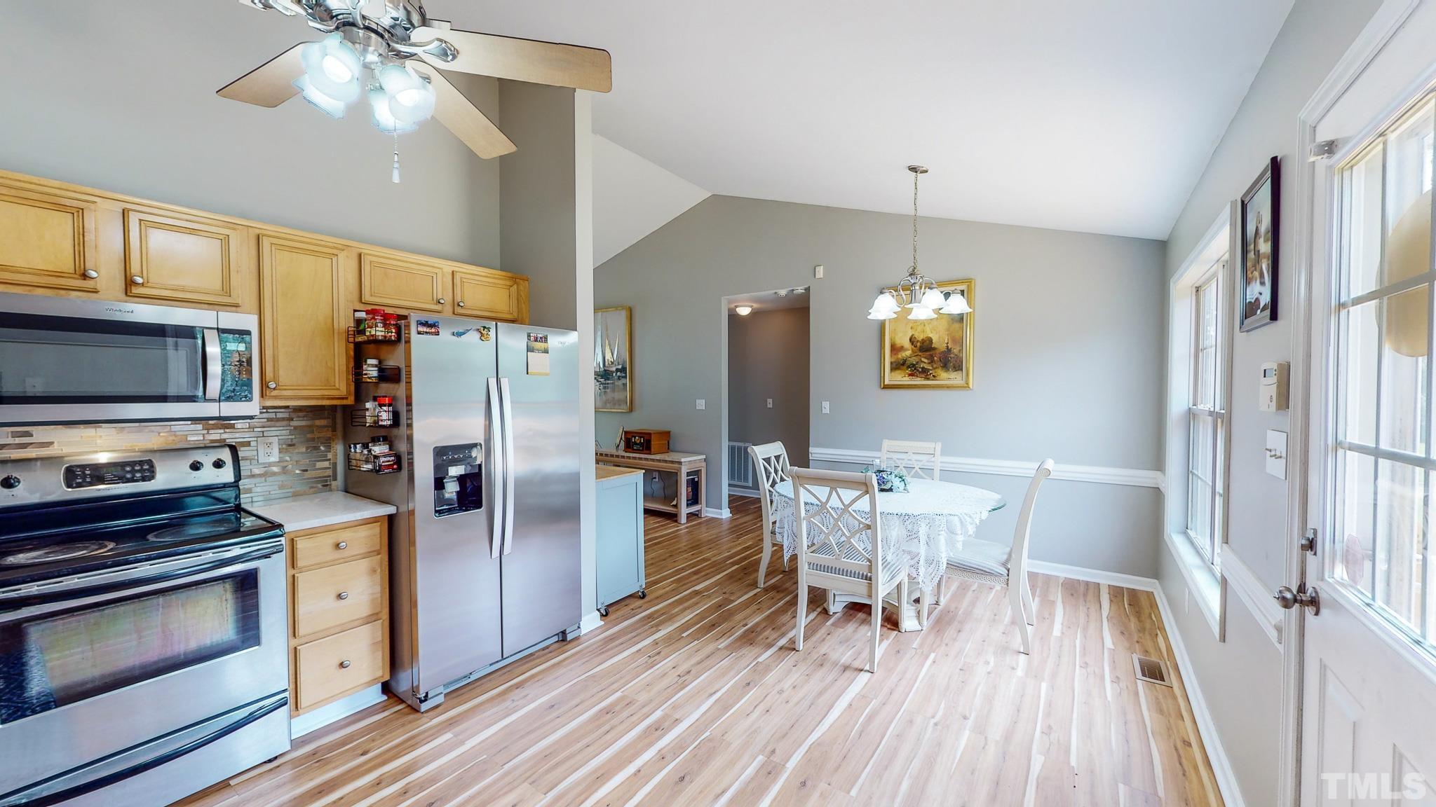 159 Punch Hill Farm Road Rougemont, NC 27572 - Photo 25 of 43 a kitchen with stainless steel appliances a dining table chairs stove refrigerator and cabinets