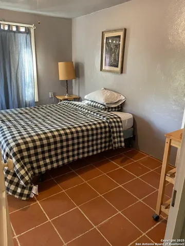 a bedroom with a bed and a painting on the wall