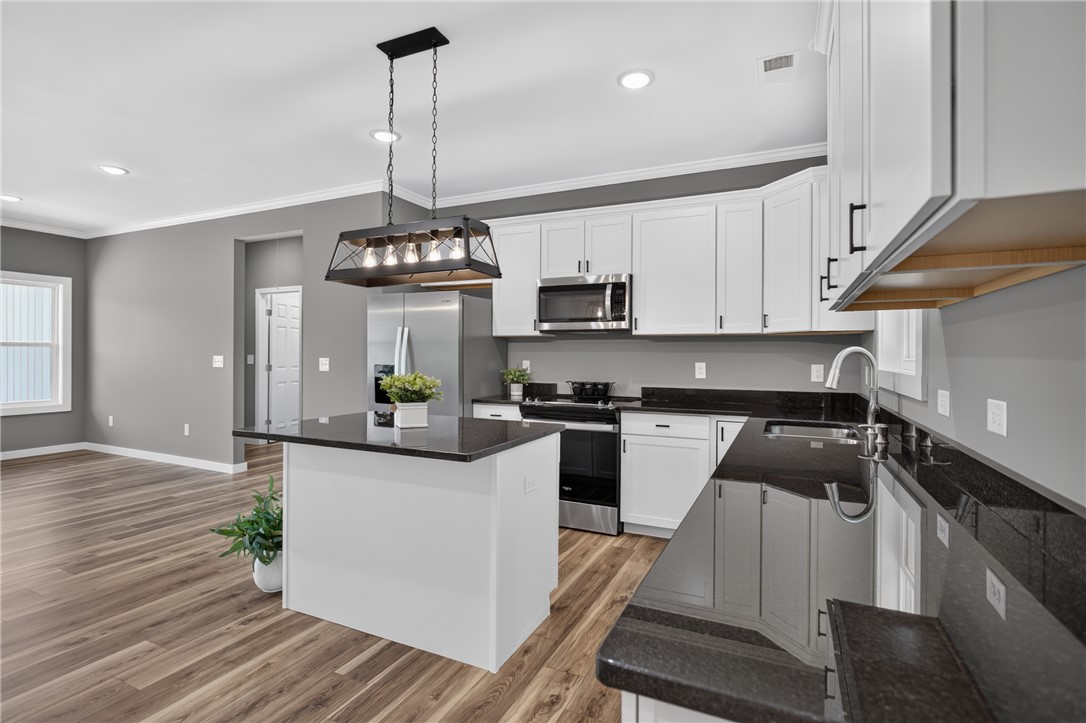 223 Maple Drive Anderson, SC 29621 - Photo 9 of 45 Granite counters and stainless steel appliances elevate this open-concept kitchen with recessed lighting.