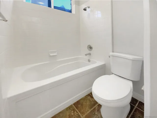 a white toilet sitting next to a bath tub