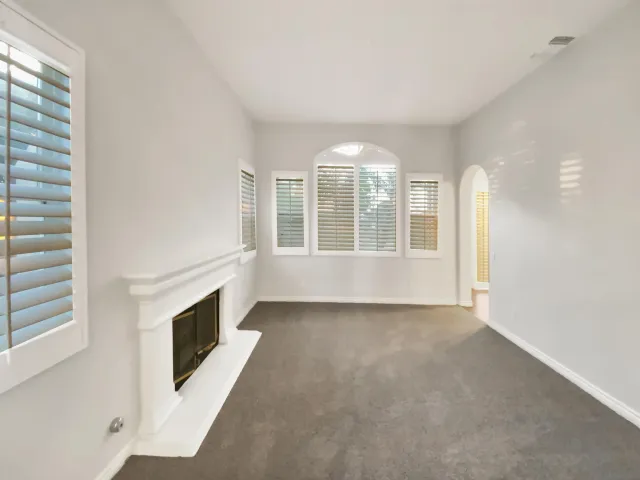 a view of an empty room with a fireplace and a window
