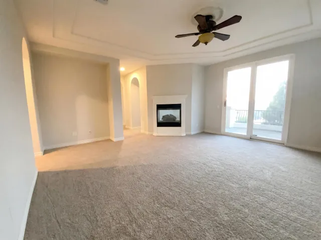 a view of a white house with a yard and potted plants