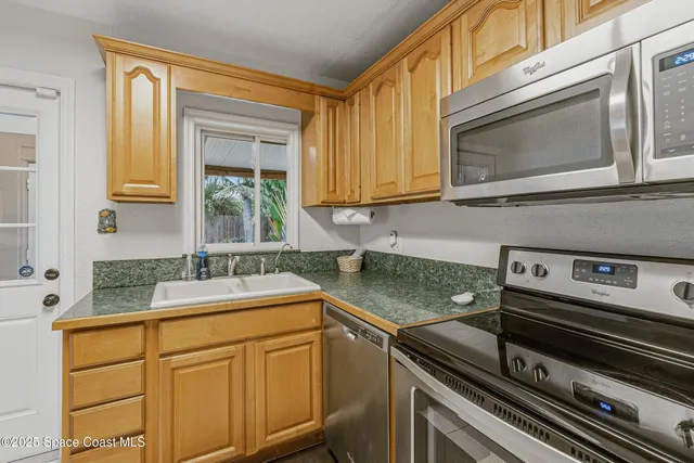 a kitchen with stainless steel appliances granite countertop a refrigerator stove and sink