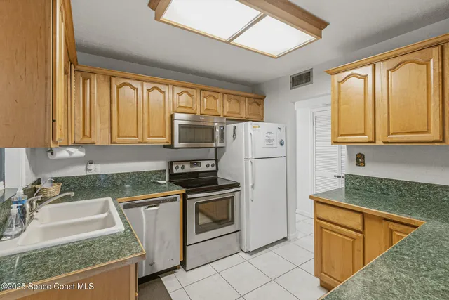 a kitchen with stainless steel appliances granite countertop a stove a sink and a refrigerator