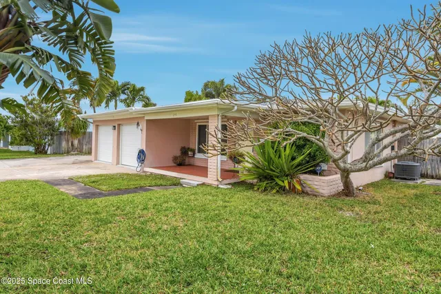 a view of a house with backyard and a tree