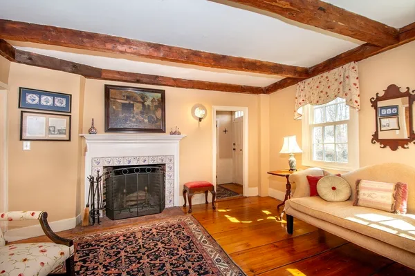 a living room with furniture rug fireplace and window