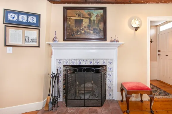 a living room with a fireplace and a painting on the wall