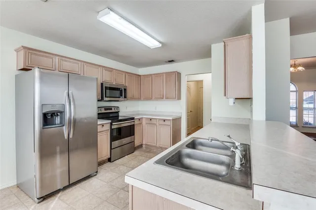 a kitchen with kitchen island a counter top space cabinets stainless steel appliances and a window