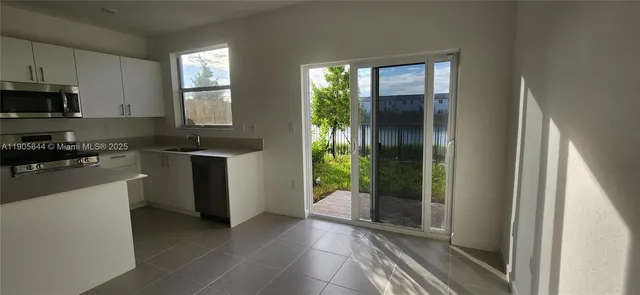 a kitchen with a sink and white cabinets