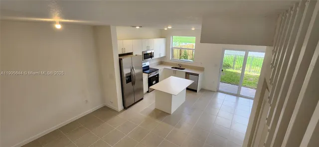a view of open kitchen with a table and chairs in a room