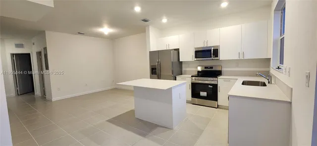 a kitchen with stainless steel appliances a refrigerator sink and microwave