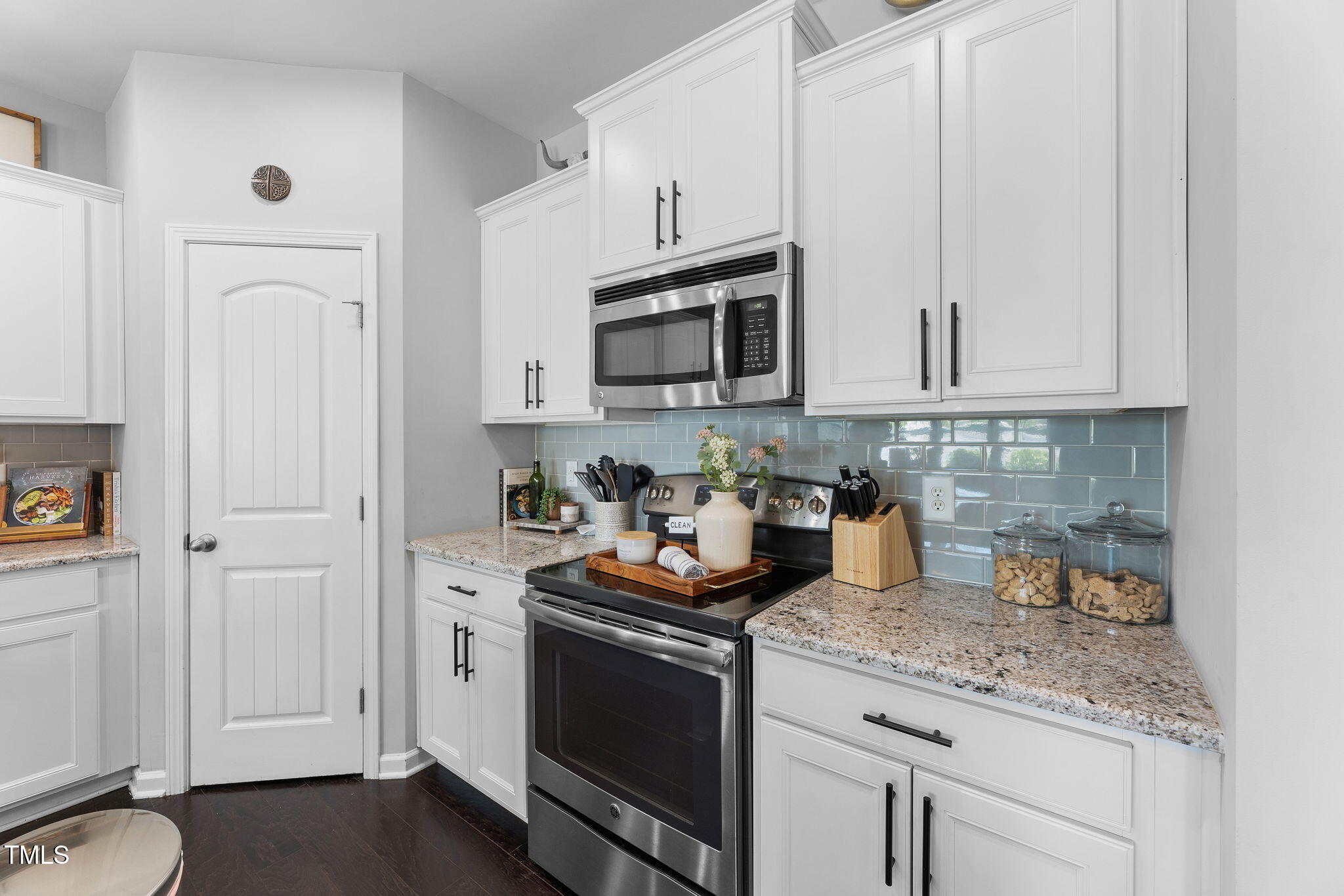 7807 Elmshire Way Raleigh, NC 27616 - Photo 14 of 32 a kitchen with stainless steel appliances granite countertop white cabinets and a stove
