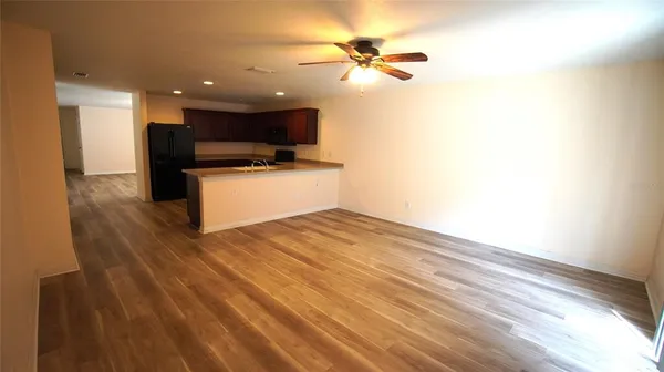 a view of kitchen with wooden floor and a ceiling fan