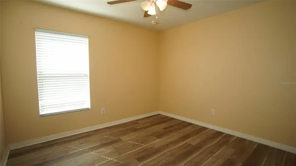 a view of a room with wooden floor and a window