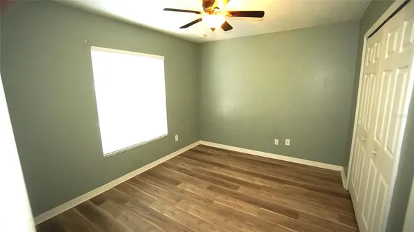 an empty room with a window and a fan