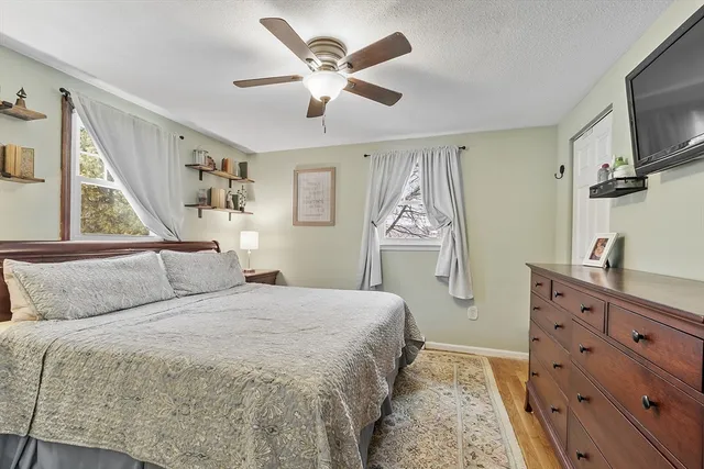a bedroom with a large bed and a flat tv screen on dresser
