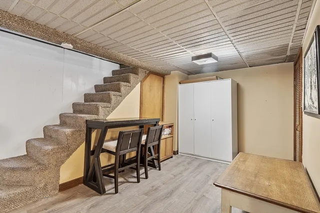 a view of an empty room with wooden floor and stairs