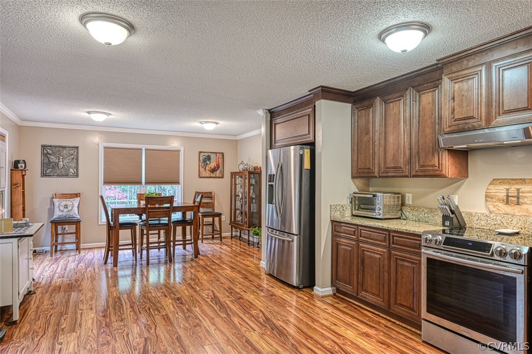 5764 Community House Road Columbia, VA 23038 - Photo 26 of 48 a kitchen with stainless steel appliances granite countertop a refrigerator a stove top oven a dining table and chairs with wooden floor