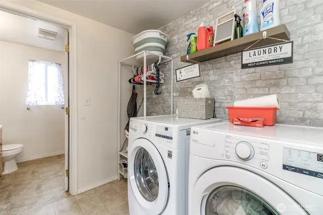 a utility room with dryer washer and a view of living room