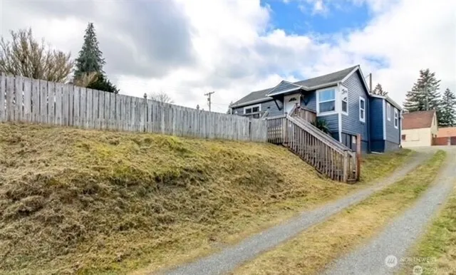 a white house that has tree in front of it