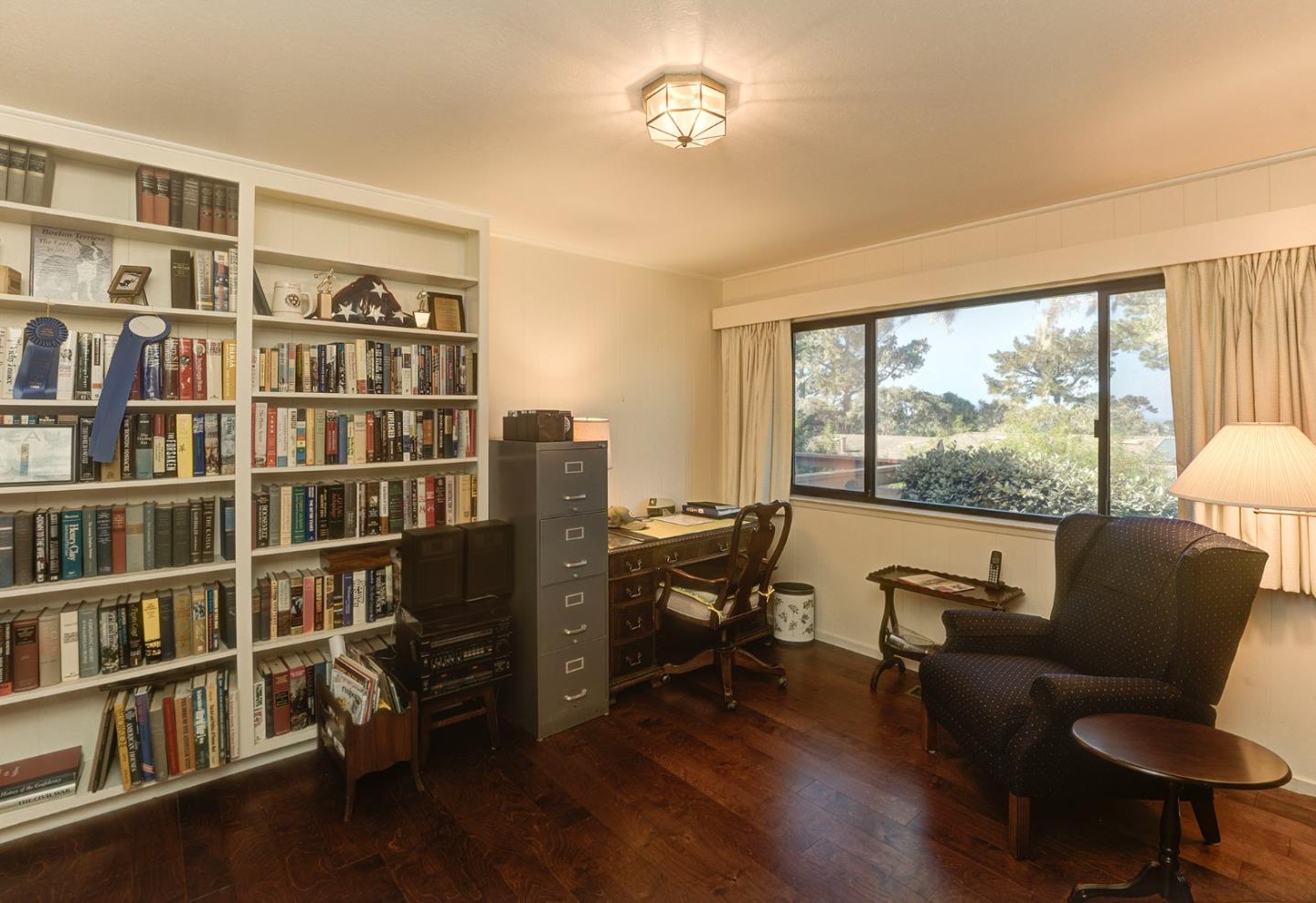 3084 Sloat Road Pebble Beach, CA 93953 - Photo 23 of 38 a living room with furniture and a book shelf