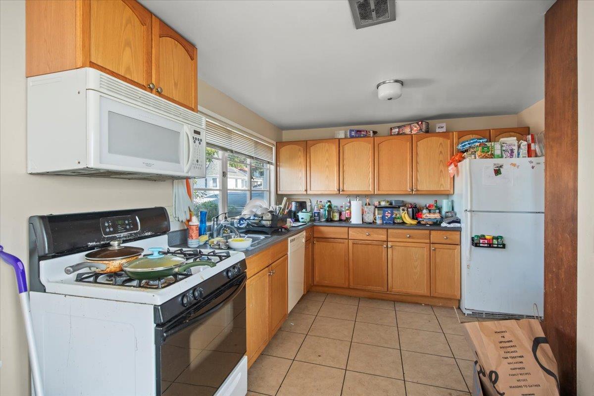 1526 Arch Street Berkeley, CA 94708 - Photo 24 of 27 a kitchen with a refrigerator a stove top oven a sink and dishwasher