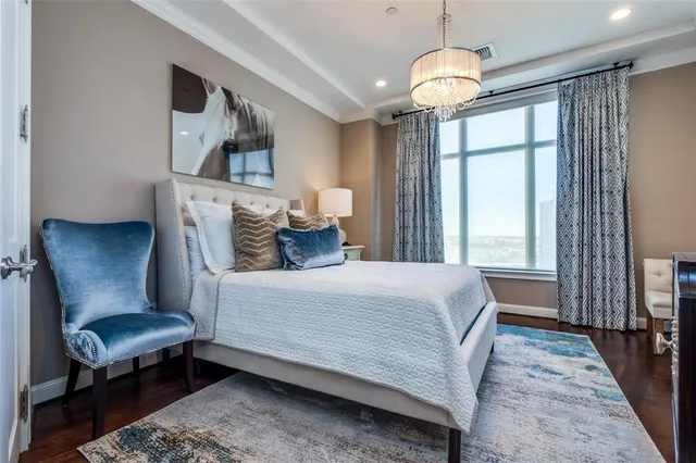 a bedroom with a bed a chandelier and a window