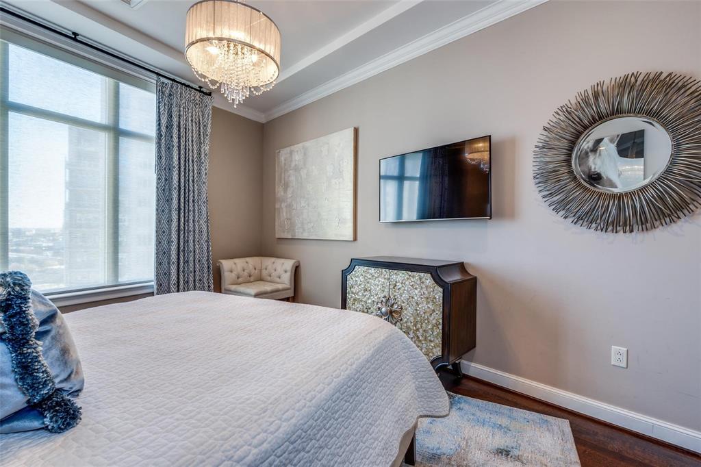 2555 North Pearl Street, Unit 1402 Dallas, TX 75201 - Photo 16 of 25 a bedroom with a bed and a chandelier