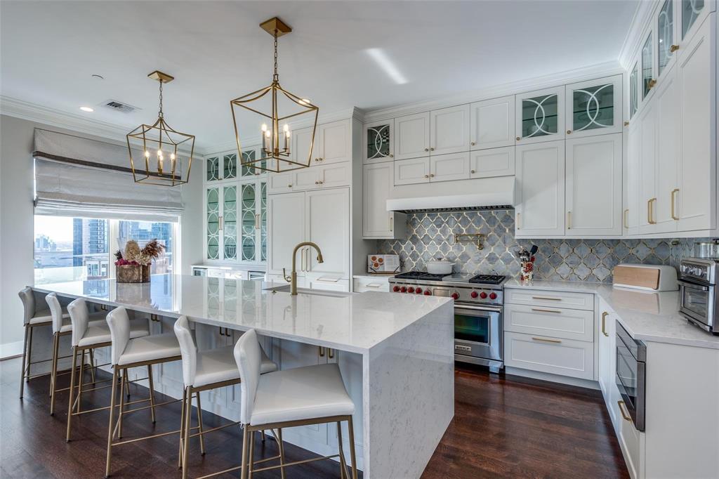2555 North Pearl Street, Unit 1402 Dallas, TX 75201 - Photo 5 of 25 a kitchen with stainless steel appliances granite countertop a stove top oven a sink a dining table and chairs with wooden floor
