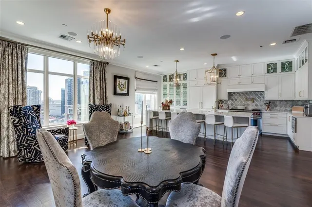 a dining room with furniture a chandelier and wooden floor