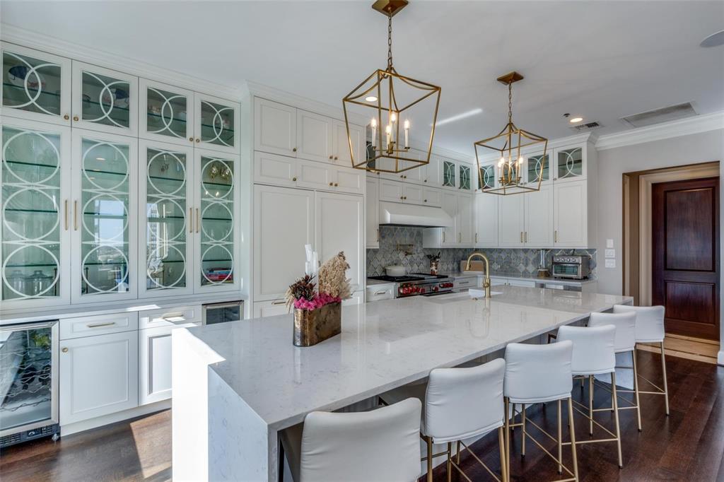2555 North Pearl Street, Unit 1402 Dallas, TX 75201 - Photo 9 of 25 a kitchen with stainless steel appliances a dining table chairs and white cabinets