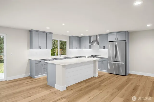 a large kitchen with kitchen island a sink stainless steel appliances and cabinets