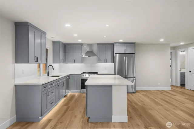 a kitchen with stainless steel appliances granite countertop a sink stove and refrigerator