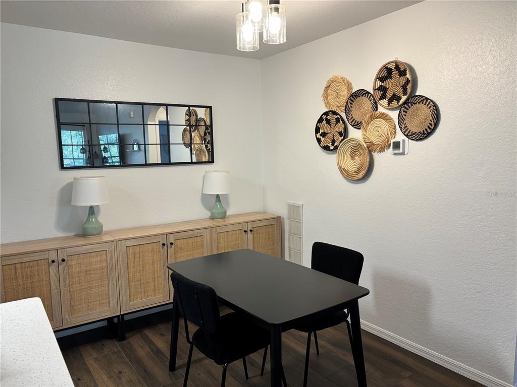 8809 Manor Loop, Unit 202 Lakewood Ranch, FL 34202 - Photo 4 of 9 a view of a dining room with a table and chairs