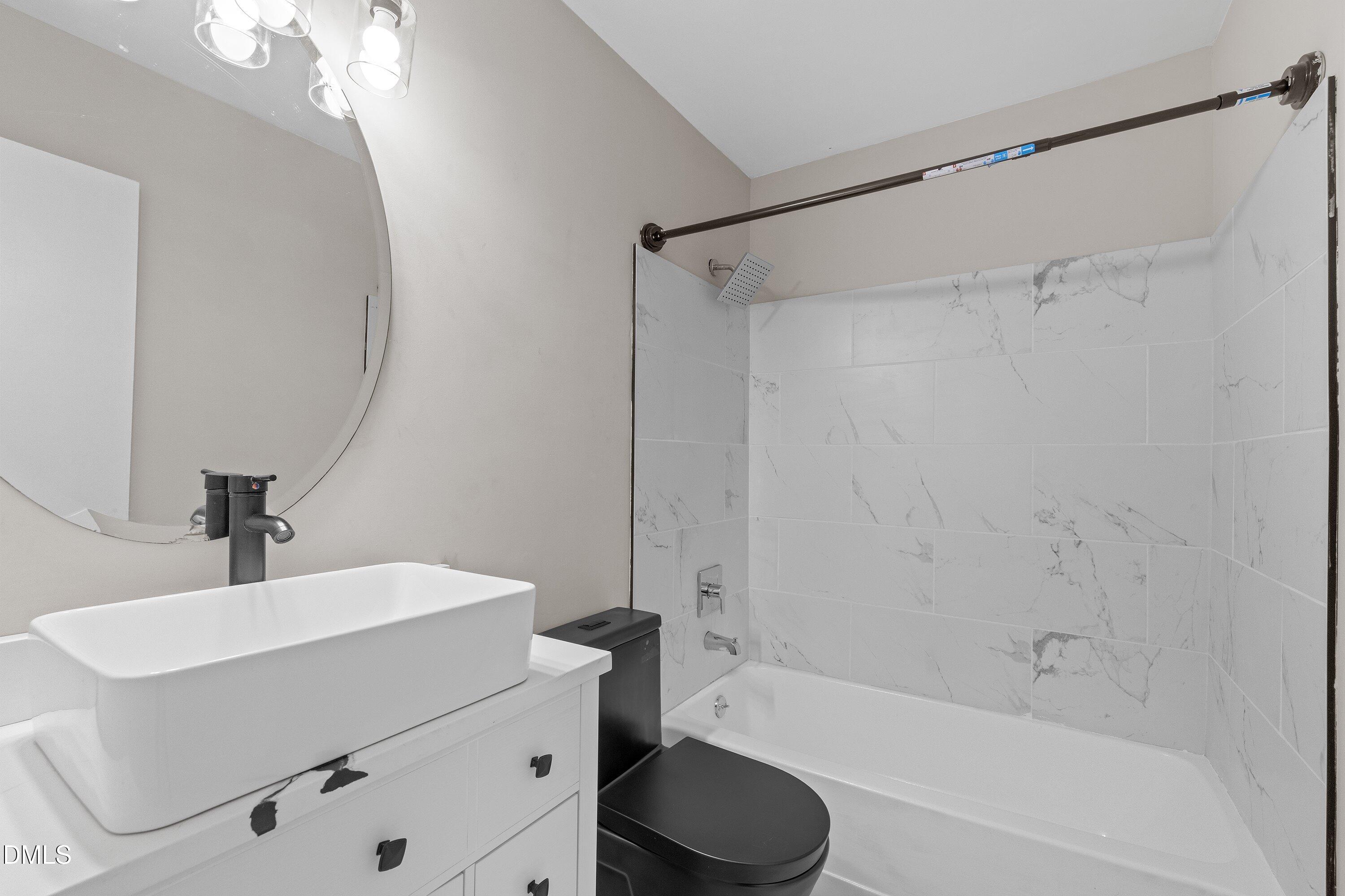887 Dalewood Drive Raleigh, NC 27610 - Photo 14 of 21 a bathroom with a bathtub a sink a toilet and a mirror
