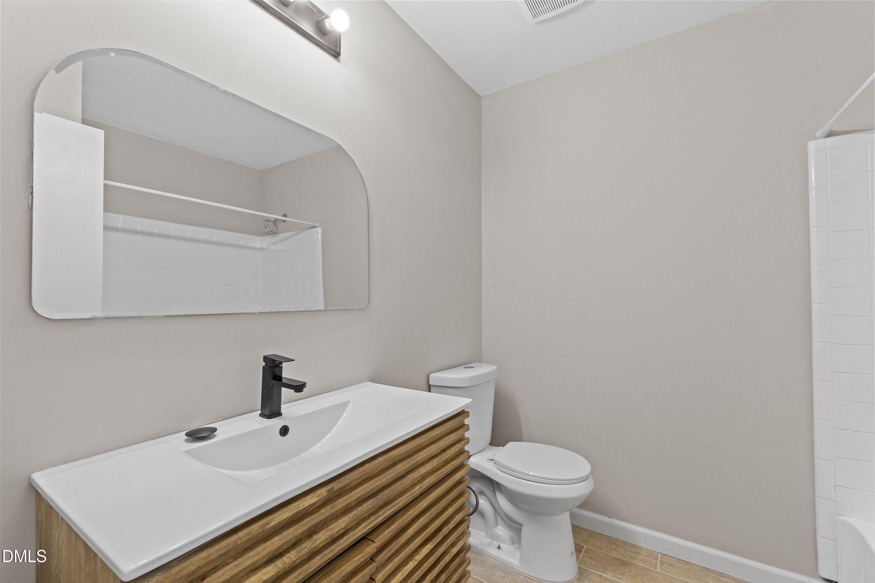 887 Dalewood Drive Raleigh, NC 27610 - Photo 16 of 21 a bathroom with a sink a toilet and mirror