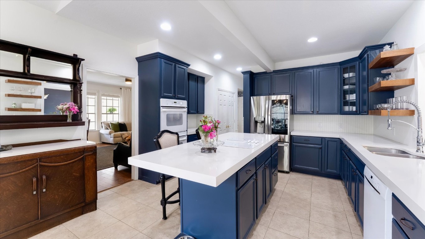 100 Lords Circle Coldspring, TX 77331 - Photo 18 of 50 a kitchen that has a sink a center island stainless steel appliances and a refrigerator