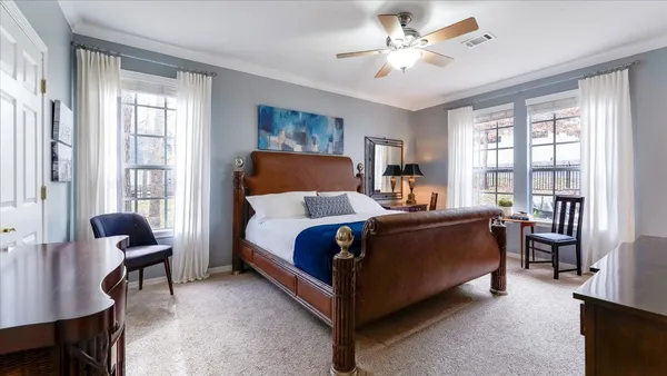 a large bedroom with a bed and a chandelier