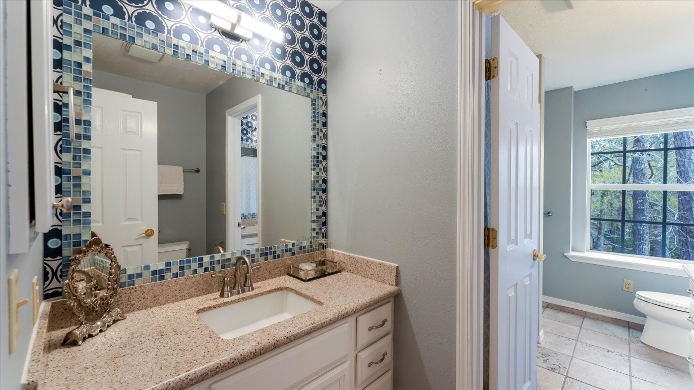 100 Lords Circle Coldspring, TX 77331 - Photo 33 of 50 a bathroom with a granite countertop sink and a mirror