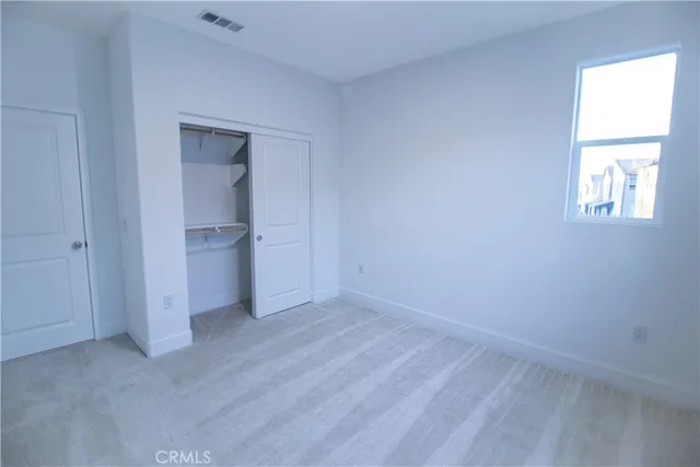 an empty room with closet and windows