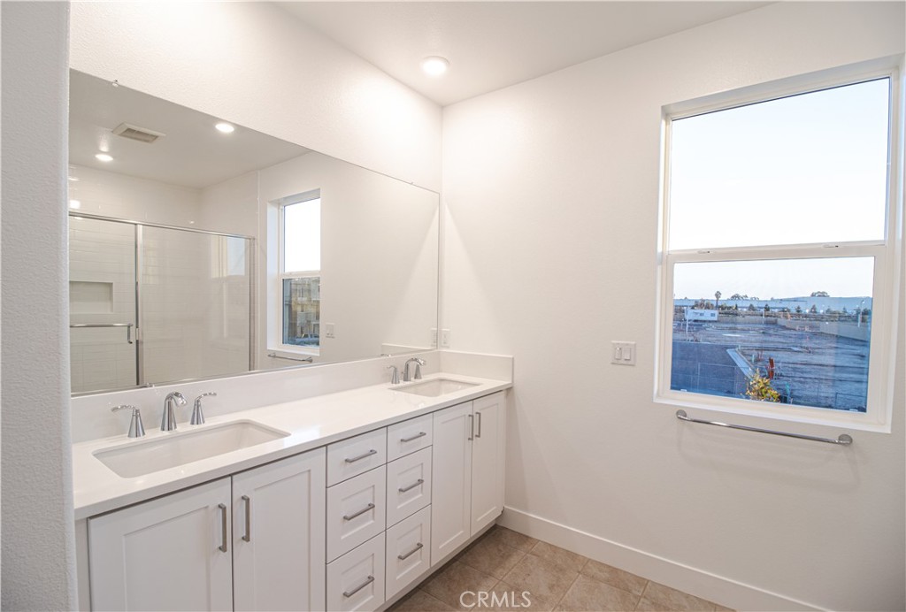 635 Gadwall Irvine, CA 92618 - Photo 18 of 27 a spacious bathroom with a double vanity sink and a mirror