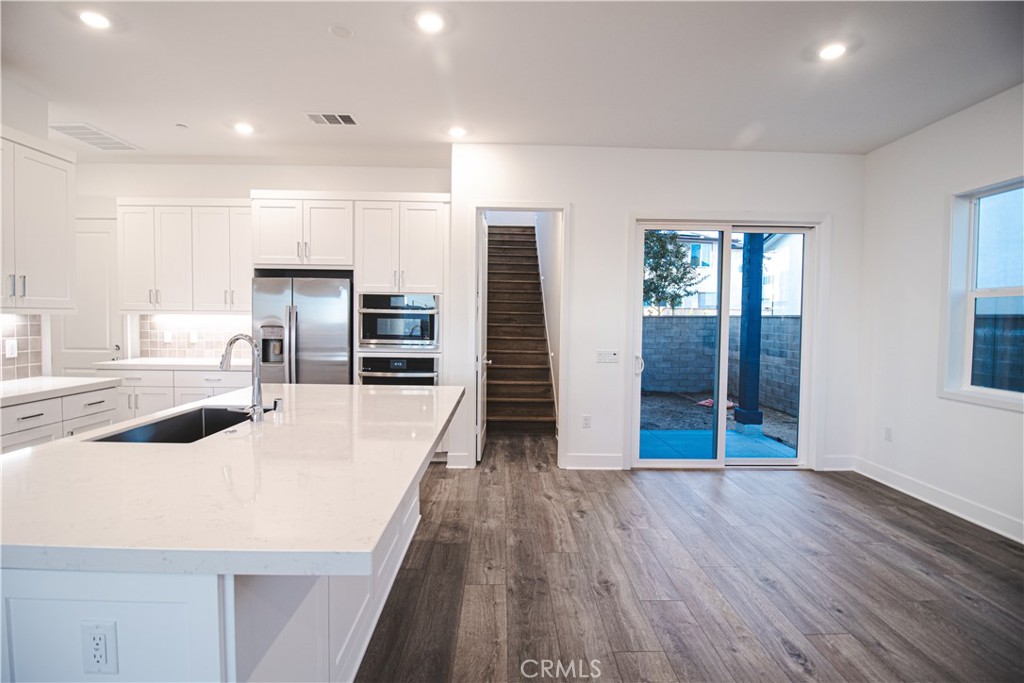 635 Gadwall Irvine, CA 92618 - Photo 21 of 27 an open kitchen with wooden floor and refrigerator