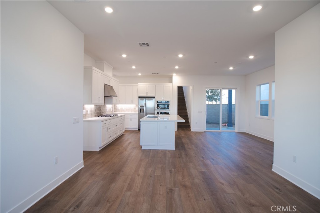635 Gadwall Irvine, CA 92618 - Photo 6 of 27 a kitchen with stainless steel appliances granite countertop a stove top oven a sink dishwasher and a refrigerator with wooden floor