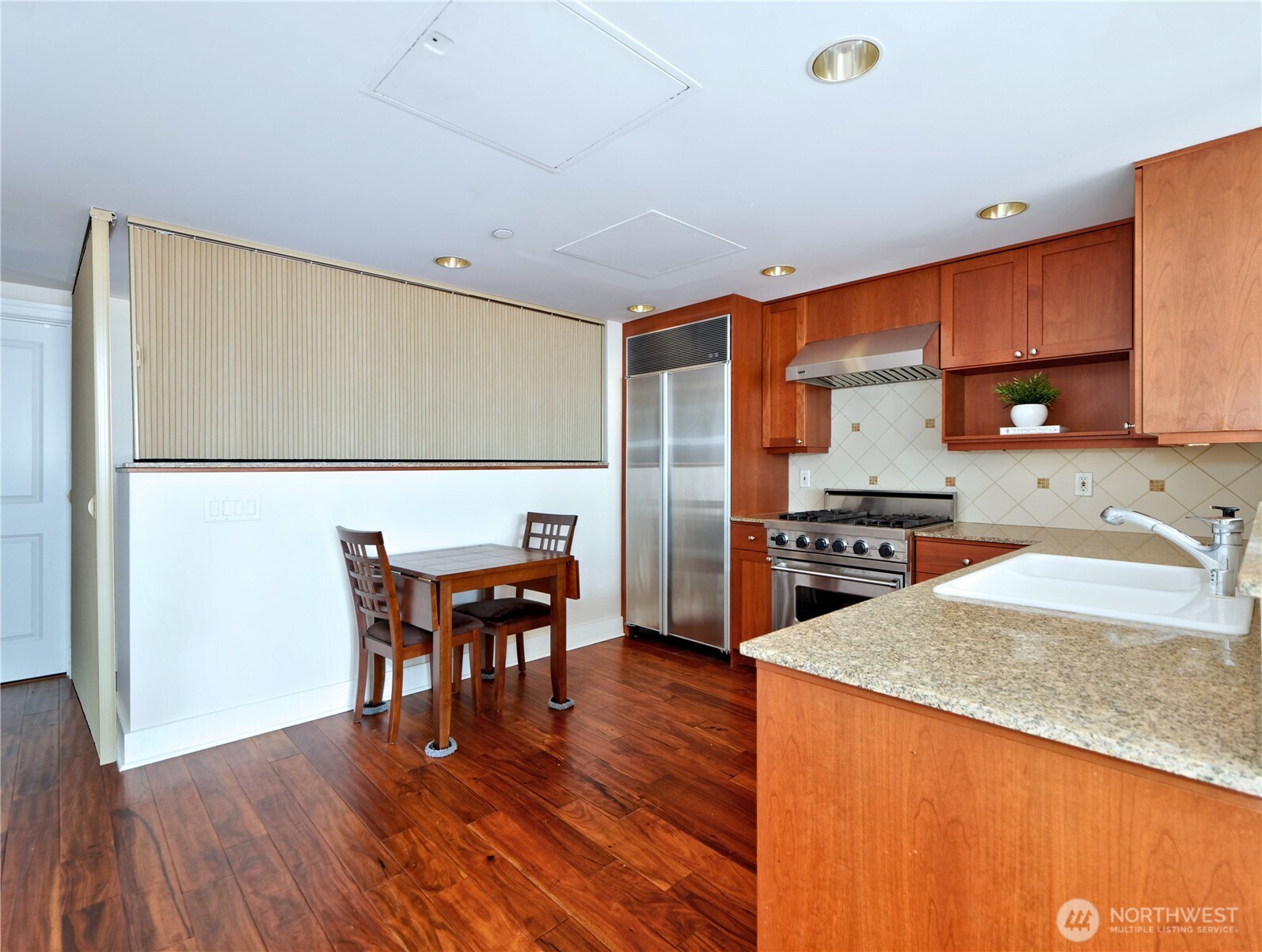 1500 4th Avenue, Unit 905 Seattle, WA 98101 - Photo 5 of 20 a kitchen with a table chairs and a refrigerator