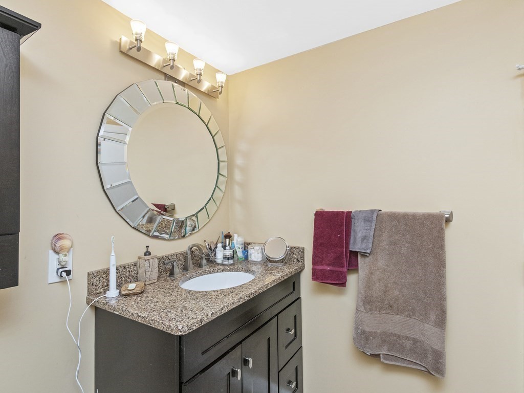 280 Boylston Street, Unit 415 Newton, MA 02467 - Photo 9 of 18 a bathroom with a granite countertop sink and a mirror
