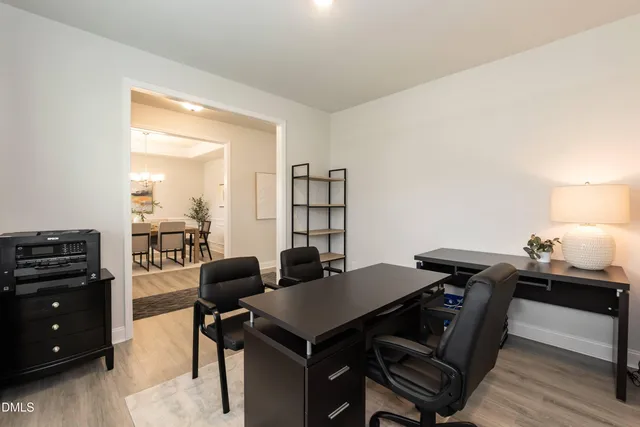 a kitchen with stainless steel appliances a stove a sink a refrigerator white cabinets and wooden floor