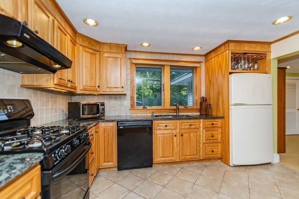 7 Ruthellen Road Chelmsford, MA 01824 - Photo 18 of 40 a kitchen with stainless steel appliances granite countertop a stove top oven a sink and a refrigerator